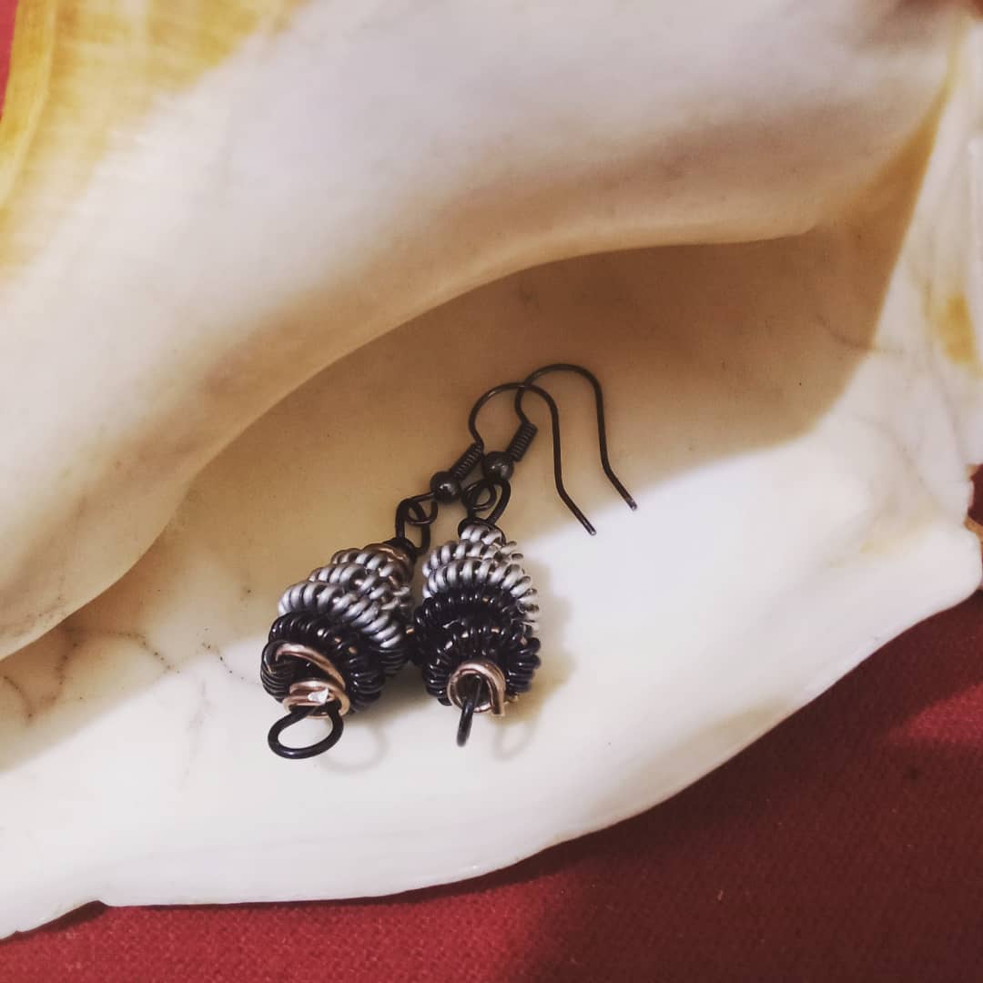 Wire wrapped earrings in a upward spiral design. Black and silver wire with black hooks wire